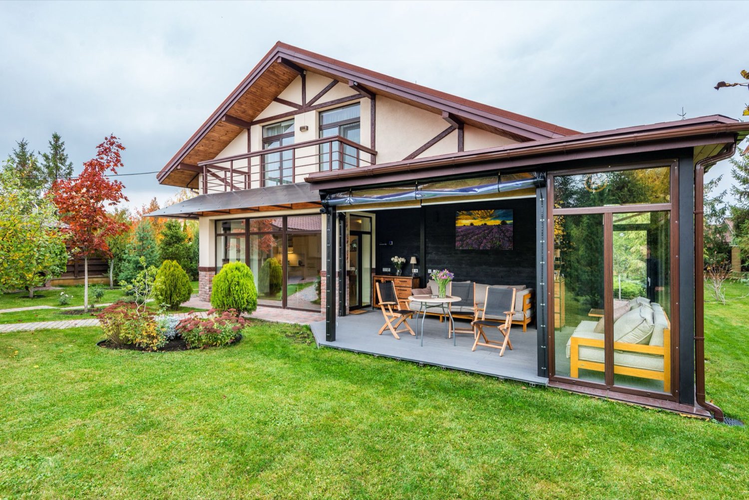 A house with a glazed garden-room extension opening onto a lawn — the kind of extension MHP Building Contractors builds